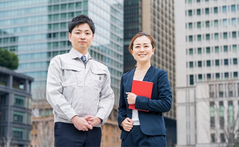 男性職員と女性職員が並んで微笑んでいる様子